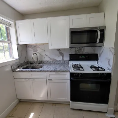 a kitchen with granite countertop a stove and a microwave