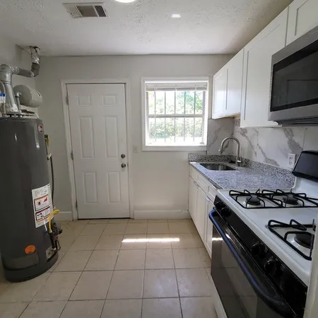 a kitchen with granite countertop a stove and a sink