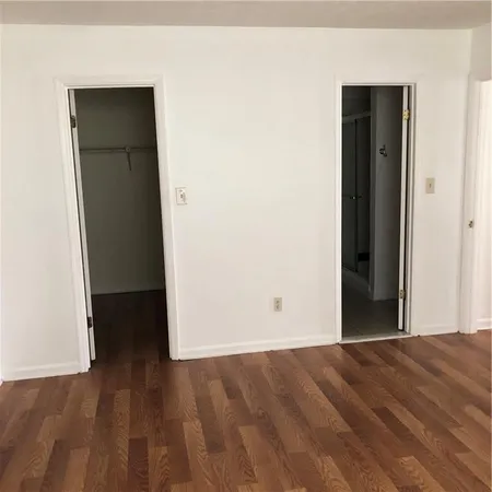 an empty room with wooden floor and closet