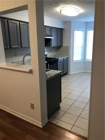 a kitchen with granite countertop a sink and a stove top oven