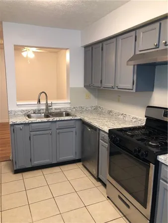 a kitchen with granite countertop a stove sink and cabinets