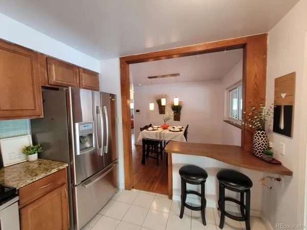 a kitchen with a table chairs refrigerator and microwave