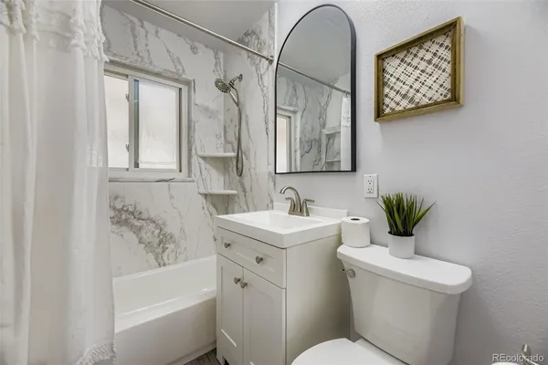 a bathroom with a sink a mirror a toilet and a bathtub