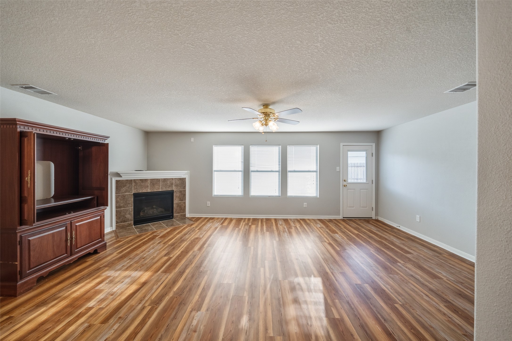 16820 Infield Court Conroe, TX 77385 - Photo 11 of 44 wooden floor fireplace and windows in an empty room