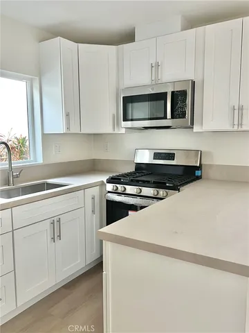 a kitchen with white cabinets and stainless steel appliances