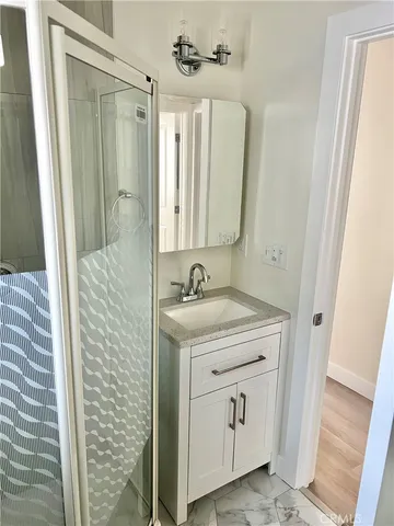 a bathroom with a granite countertop sink a mirror and a shower
