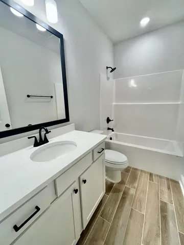 a bathroom with a granite countertop sink toilet a large mirror and shower