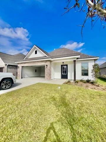 a front view of a house with a garden and yard