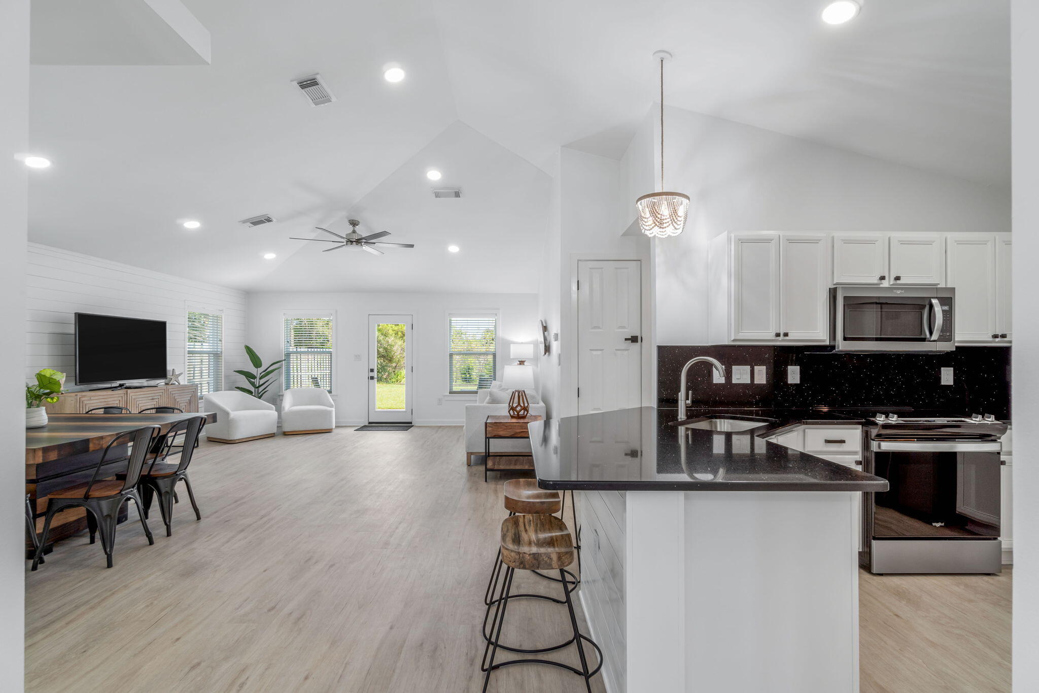 223 Sandy Cay Drive Miramar Beach, FL 32550 - Photo 6 of 79 a kitchen with stainless steel appliances kitchen island granite countertop a stove top oven a sink a dining table and chairs with wooden floor