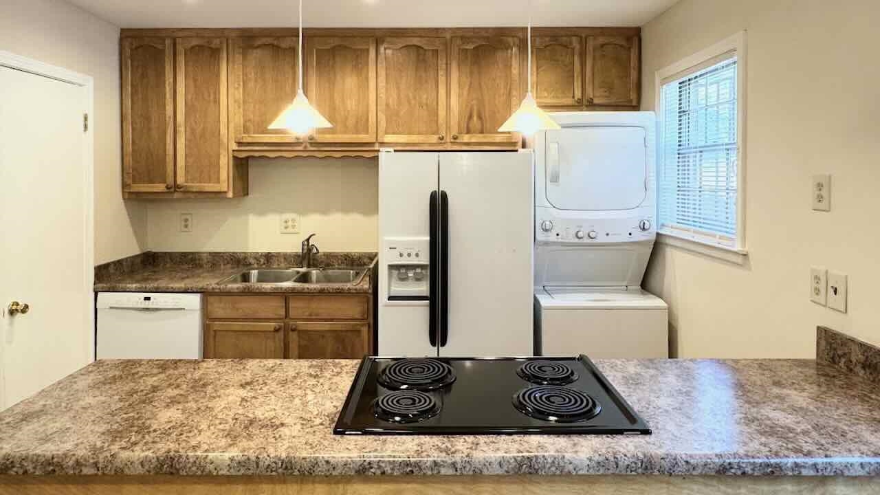 5718 Quince Road, Unit 10 Memphis, TN 38119 - Photo 7 of 28 a kitchen with kitchen island granite countertop a sink stove and refrigerator