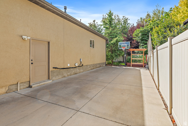 552 East Johns Way Sandy, UT 84070 - Photo 67 of 67 Extensive paved surface, stucco exterior, privacy fencing, and mature perimeter trees