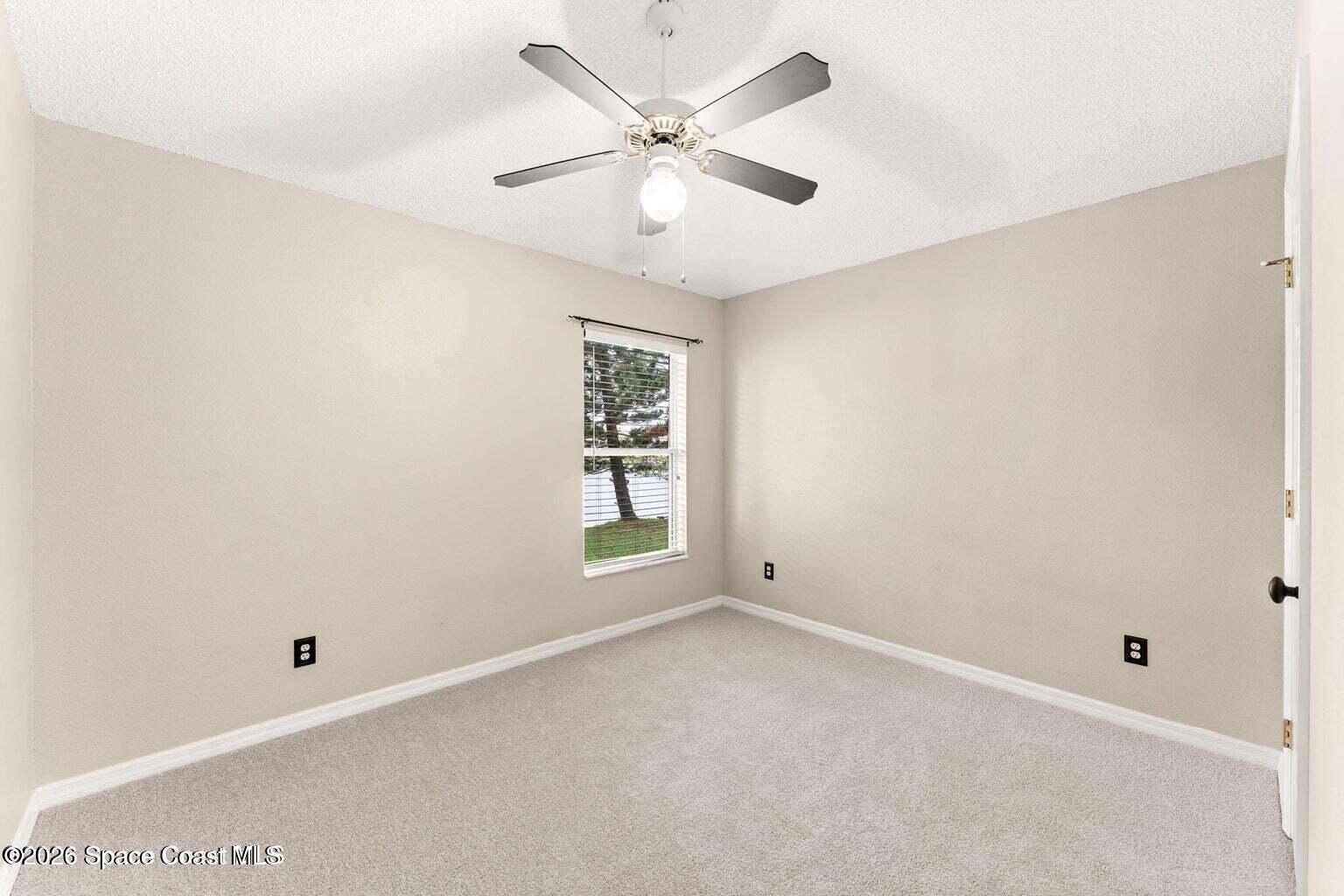 4741 Decatur Circle Melbourne, FL 32934 - Photo 21 of 44 an empty room with a window and a fan