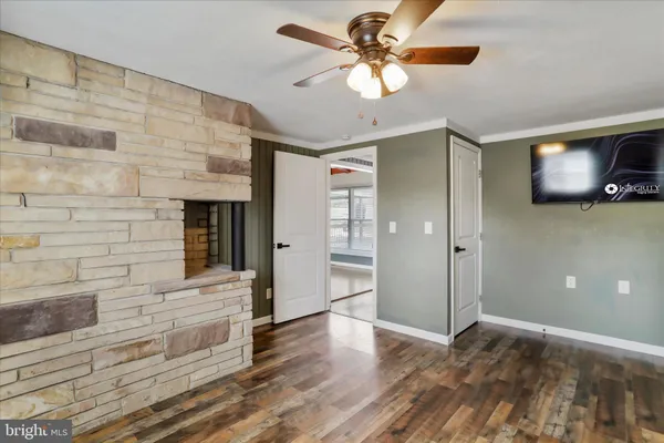 a view of an empty room with window and wooden floor