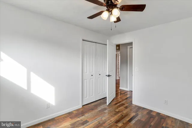 a view of an empty room and window with wooden floor