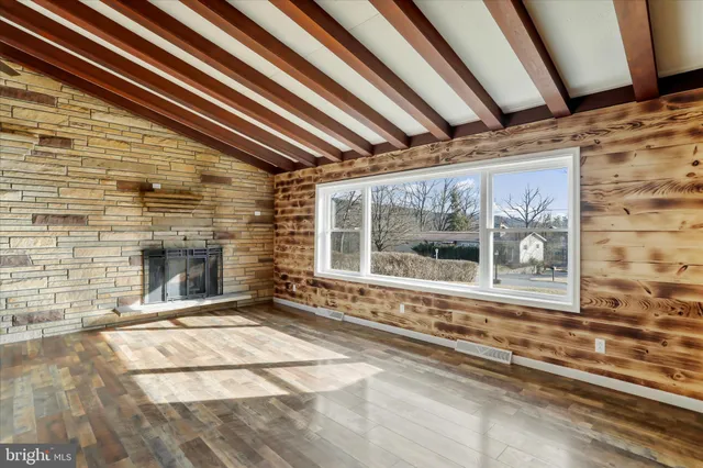 a view of a room with a wooden floor and a fireplace