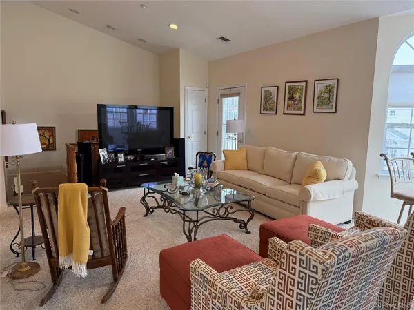 a living room with furniture a fireplace and large windows