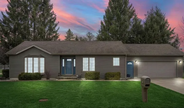 a front view of a house with a garden and yard