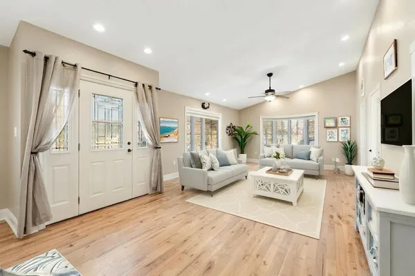 a view of an empty room with wooden floor and a window