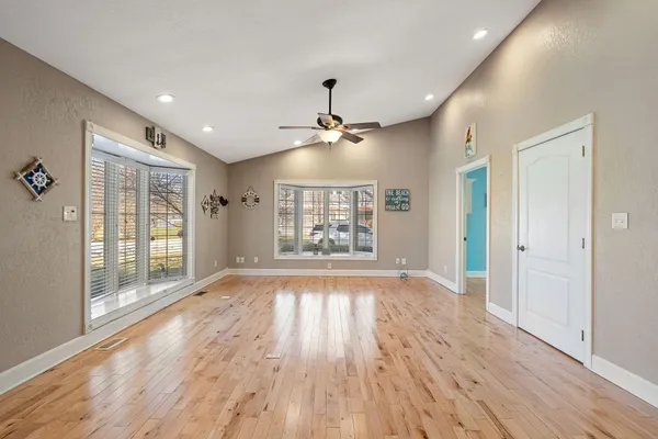 a view of an empty room and kitchen view