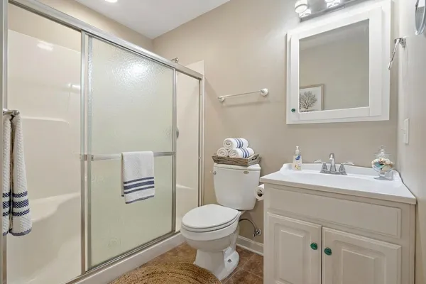 a bathroom with a toilet sink vanity and mirror