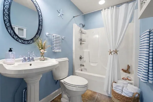 a bathroom with a sink a mirror a toilet and a mirror