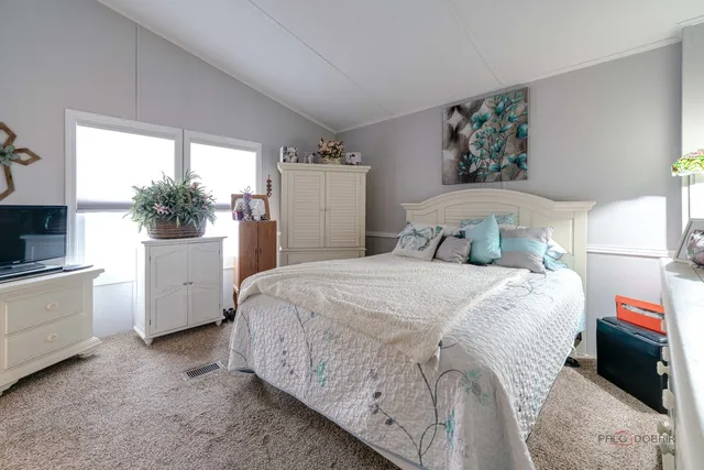 a bedroom with a bed and a large window