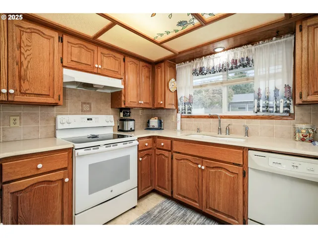 a kitchen with stainless steel appliances granite countertop a sink a stove and cabinets