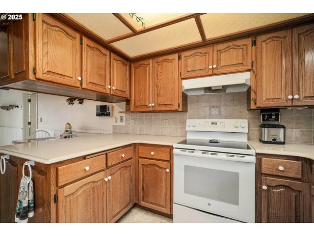 a kitchen with stainless steel appliances granite countertop a sink stove and cabinets