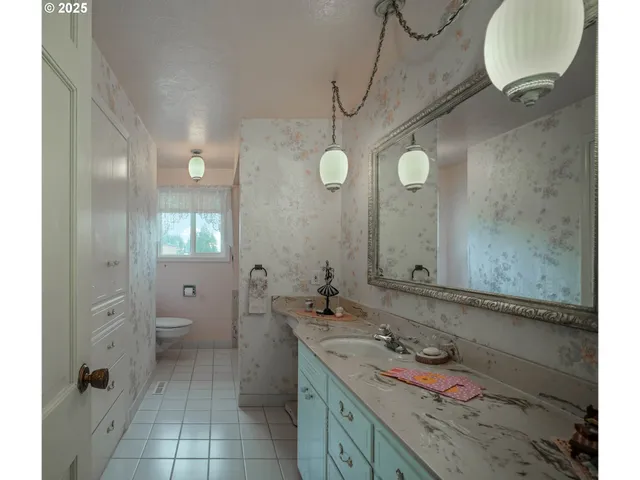 a bathroom with a granite countertop sink mirror and a toilet