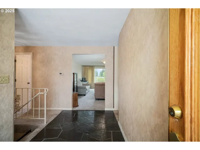 a view of a hallway with wooden floor and windows