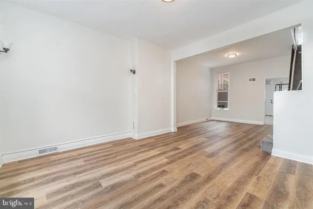 a view of empty room with wooden floor
