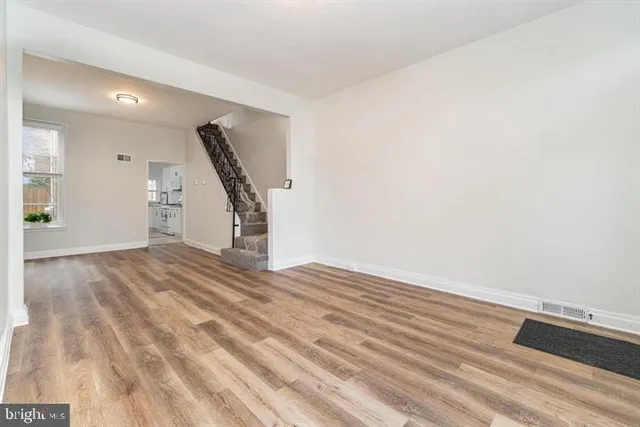 a view of empty room with wooden floor