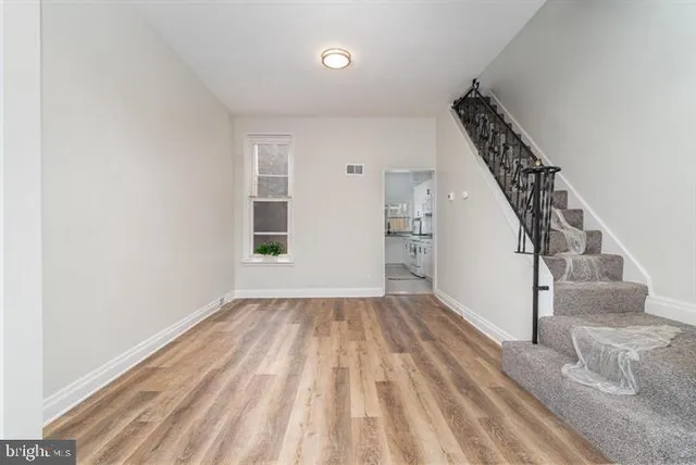 a view of entryway and hall with wooden floor