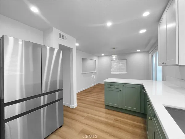 a kitchen with stainless steel appliances granite countertop a refrigerator and a sink