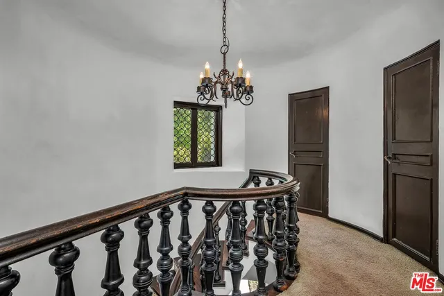 a dining room with wooden floor a chandelier and a window