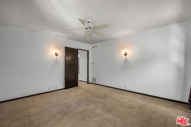 an empty room with fan and windows