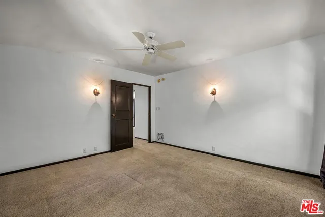 an empty room with fan and windows