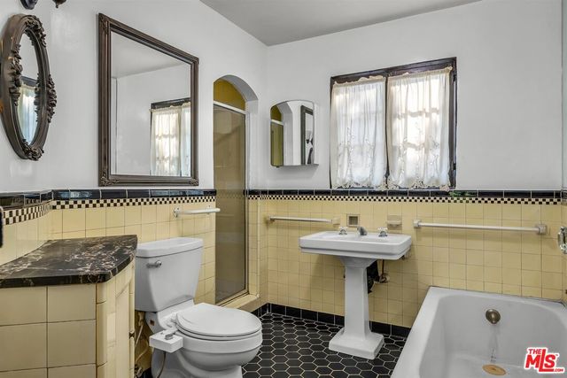 a bathroom with a sink a toilet and a mirror