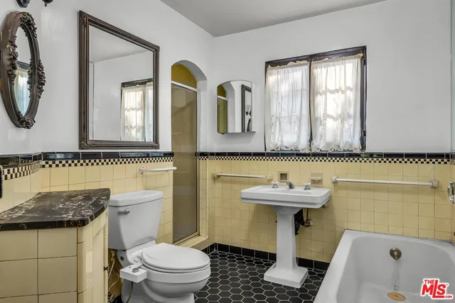 a bathroom with a sink a toilet and a mirror