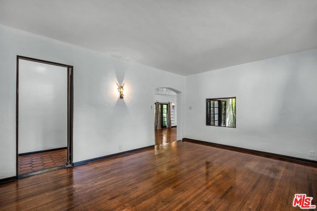a view of a big room with wooden floor and windows