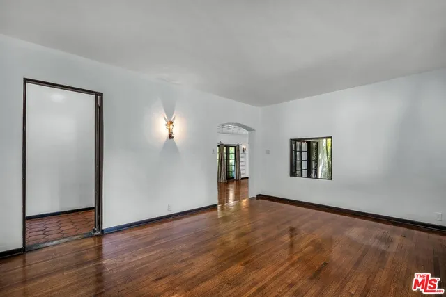 a view of a big room with wooden floor and windows