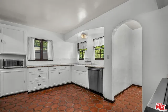 a kitchen with granite countertop white cabinets and white appliances