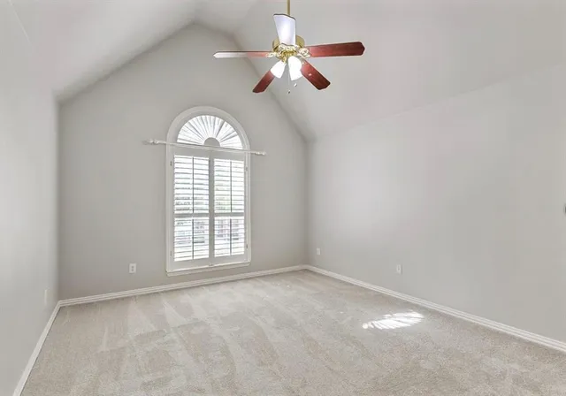 a view of an empty room and chandelier fan