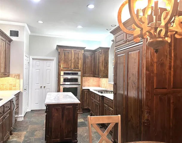 a kitchen with a refrigerator and a stove top oven