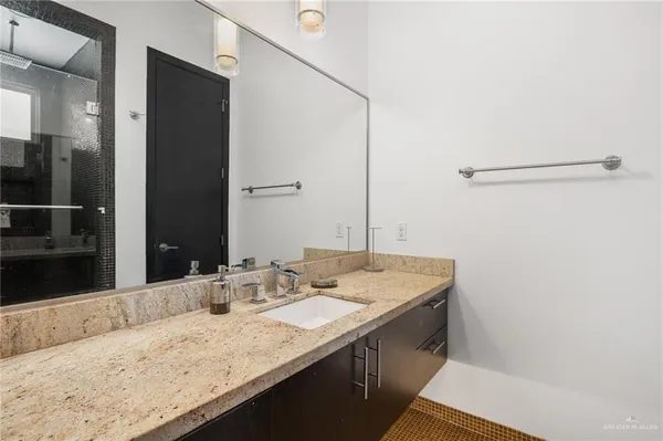 a bathroom with a granite countertop sink and a mirror