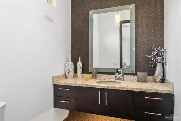 a bathroom with a granite countertop sink and a mirror