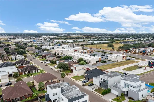 an aerial view of a city with lots of residential buildings ocean and mountain view in back