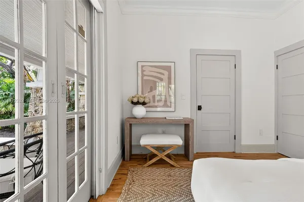 a view of a patio with couches and table and chairs under an umbrella with wooden floor and fence