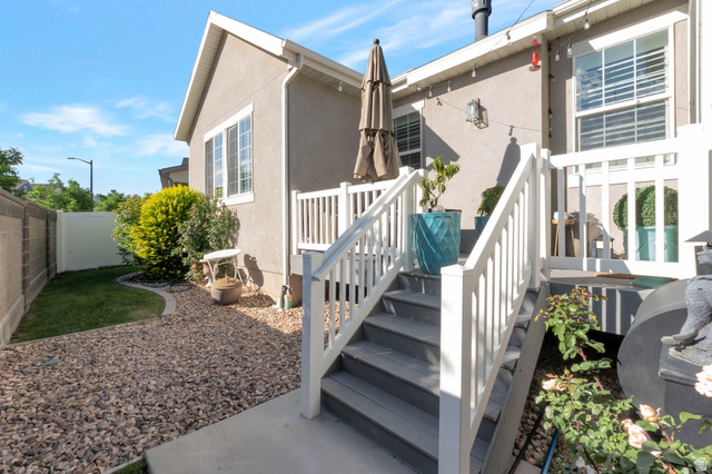 2319 North 3370 West Lehi, UT 84048 - Photo 29 of 30 Outdoor deck with white railing, gray-toned stairs, and adjacent gravel landscaping