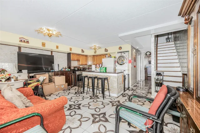a living room with furniture a flat screen tv and kitchen view